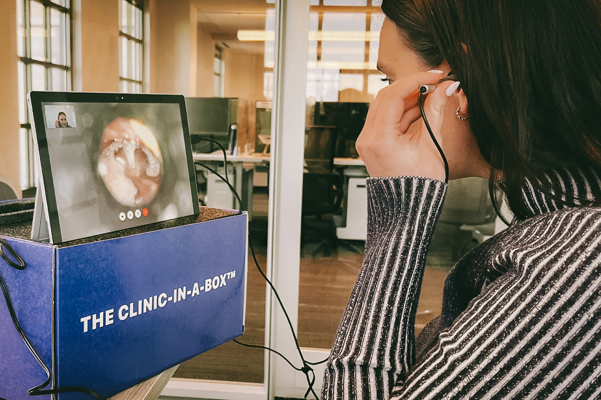 Brunette woman using an ear camera and viewing the video on a tablet screen